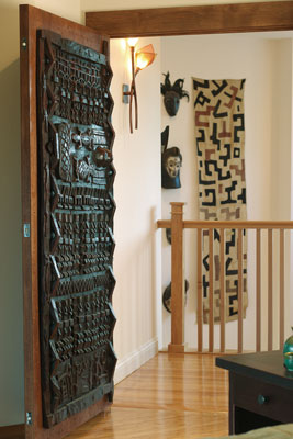 An intricately carved door from Mali marks the bedroom’s entry.